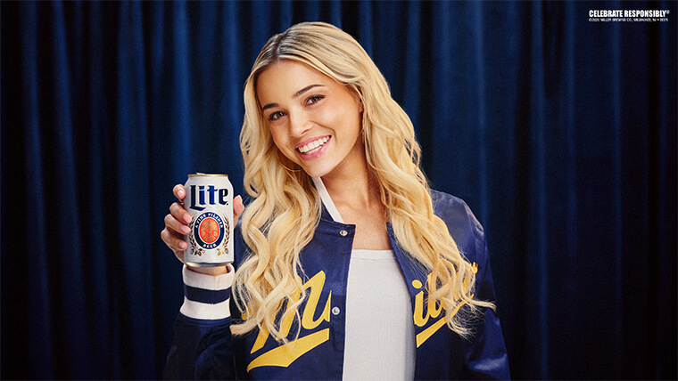 Livvy smiling, holding a miller lite